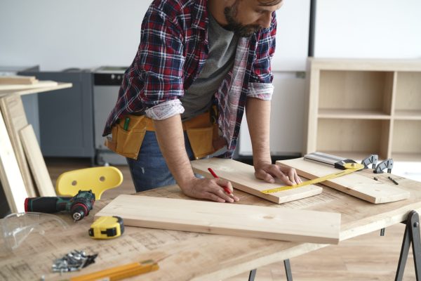 Carpenter measures the boards at the table